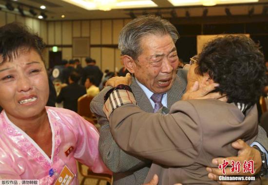 84岁的韩国人Min Ho-shik（中）终于见到了自己81岁的妹妹Min Eun Shik，两人相拥而泣。